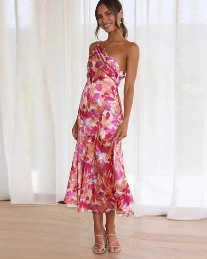 Woman wearing the Genevieve floral asymmetric midi dress in orange with a flowing silhouette