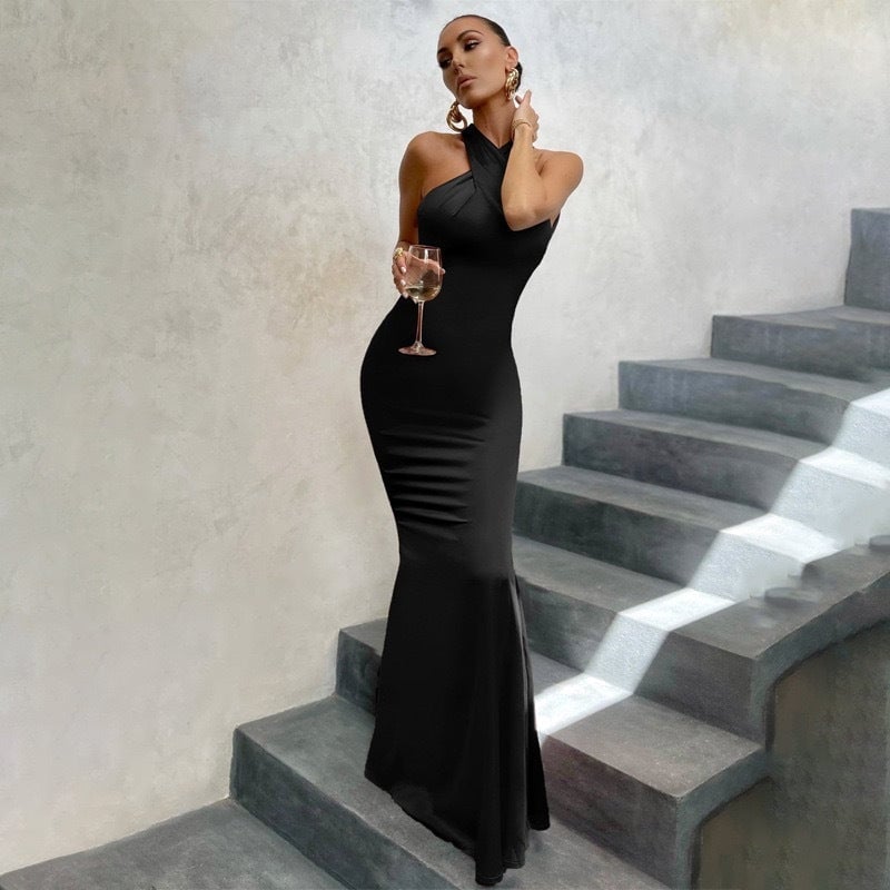 Woman wearing an elegant black fitted fishtail dress with an open back, showcasing the sculpted silhouette and dramatic hem