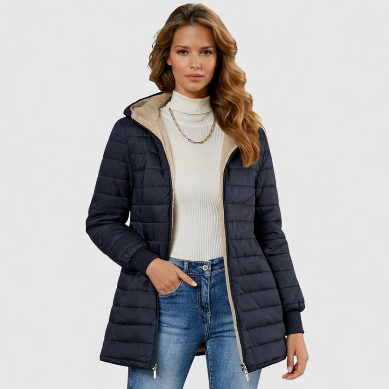 Woman in the Geraldine sherpa-lined coat in black, styled with ankle boots and wide-leg trousers