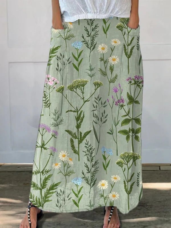 Model wearing a green spring floral repeat print A-line midi skirt with side pockets and elastic waistband