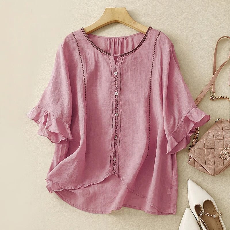 Model wearing pink ruffle sleeve blouse in a casual outdoor setting