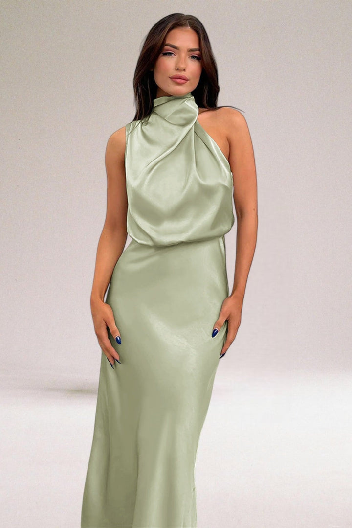 Woman wearing an elegant halter neck dress in a flowing luminous fabric, front view showing tailored silhouette