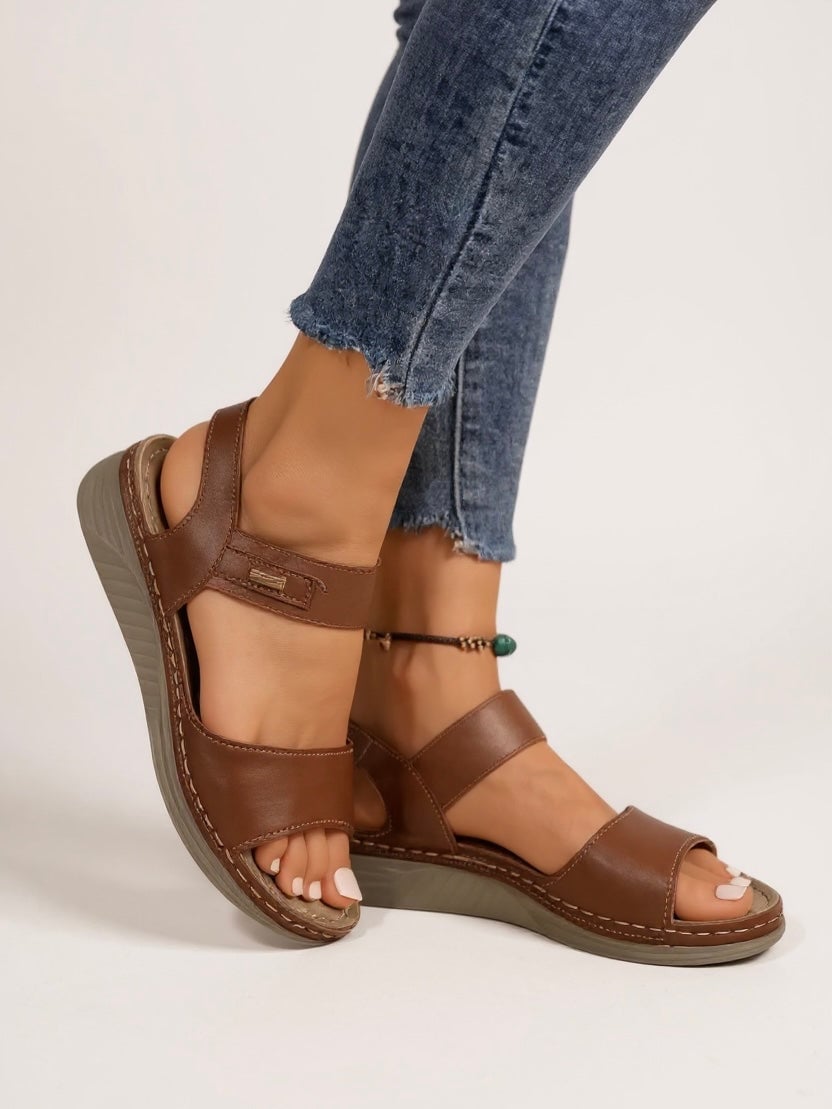 Overhead flat-lay of all three Giselle sandal colorways — brown, black, and beige