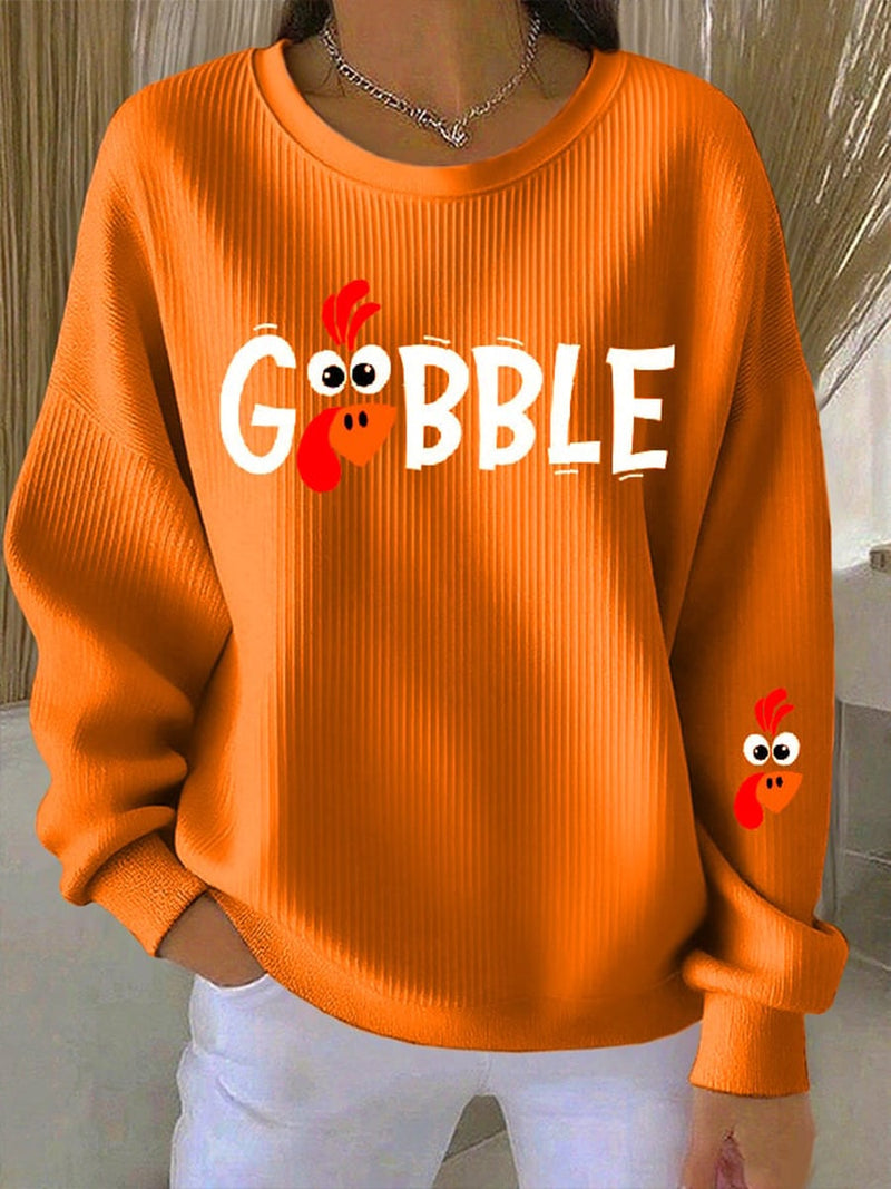 Model wearing the Gobble Season graphic sweatshirt in orange with a relaxed fit, styled for fall