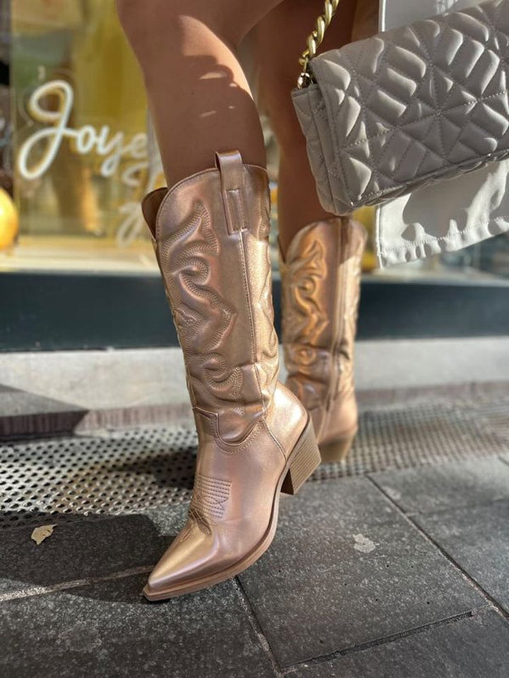 Pair of silver metallic cowboy boots styled with denim jeans