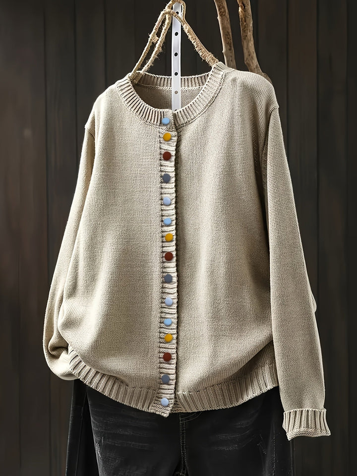 Close-up of decorative button detail on a women's comfortable everyday cardigan in light pink