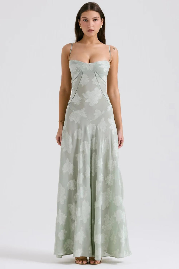 Model in a long green summer maxi dress with adjustable straps, relaxed flowing fit, outdoor setting