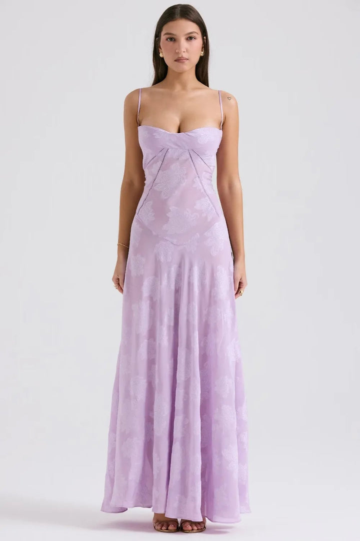 Woman wearing a long purple open-back summer dress with spaghetti straps, elegant and breezy style