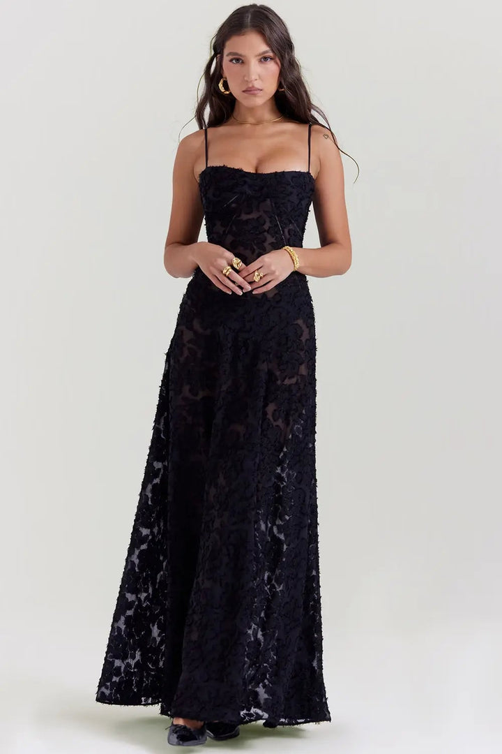 Side view of a long black summer dress showing the open back and flowing hem detail