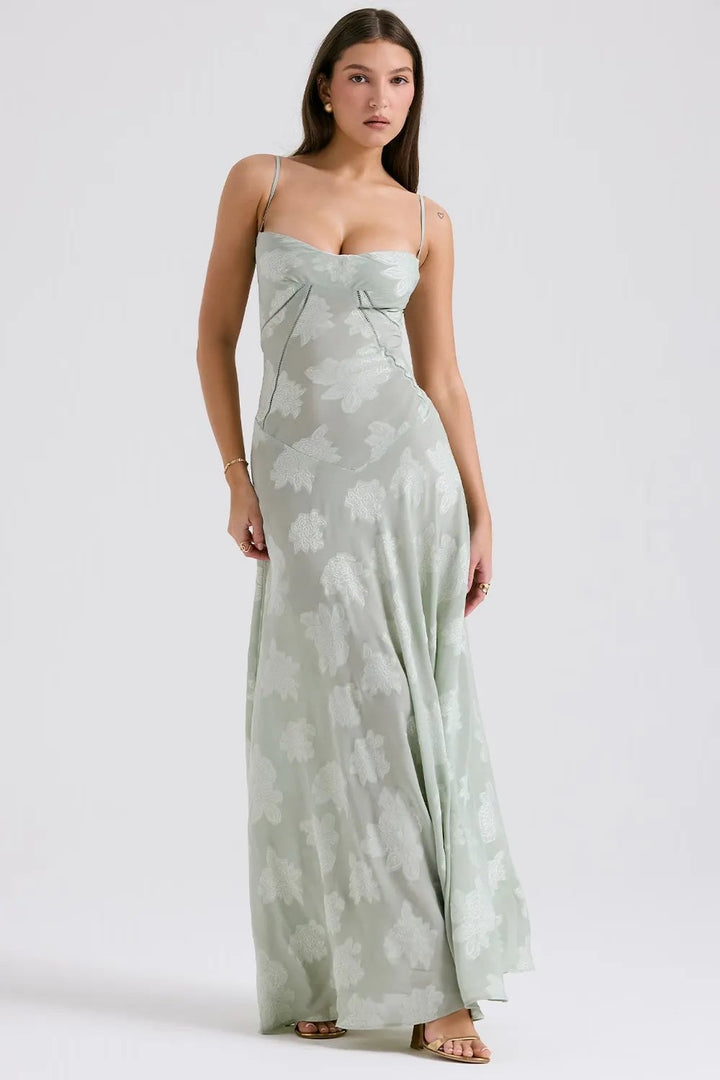 Model in a long green open-back dress with adjustable spaghetti straps, relaxed summer style