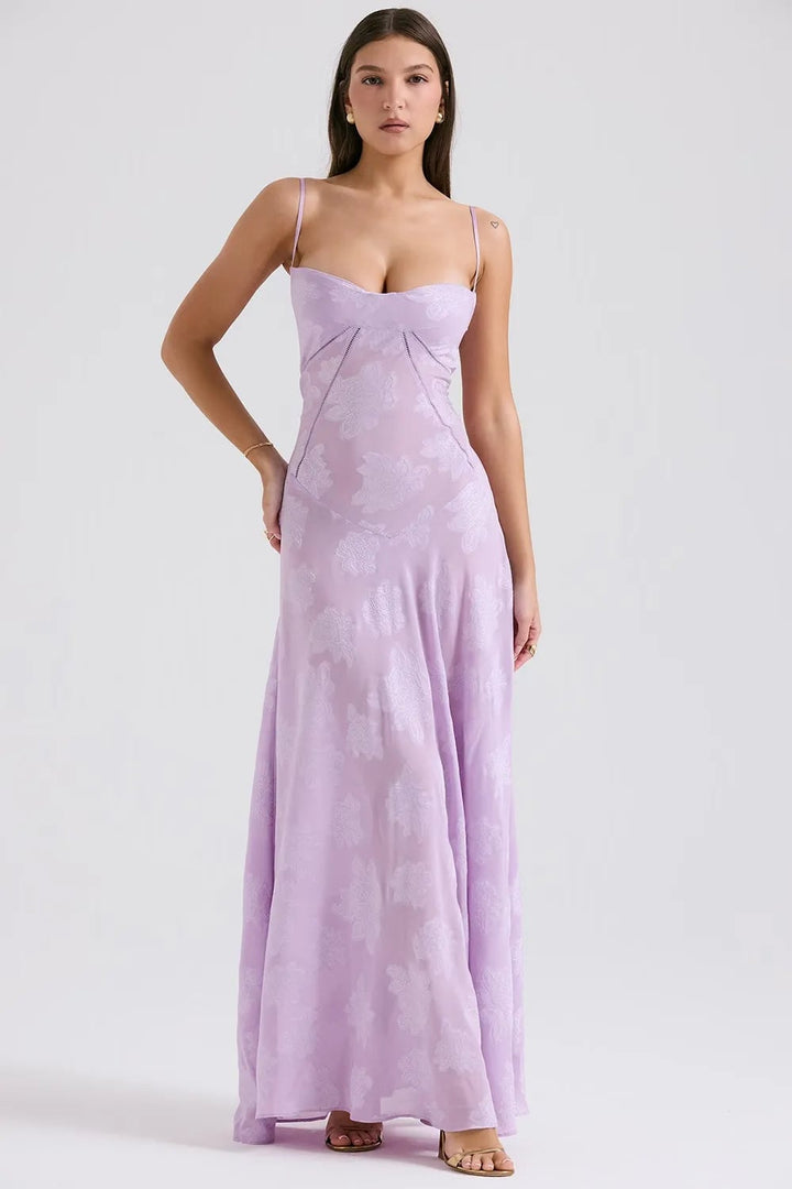 Woman in a long green summer dress with adjustable straps, posing near the water