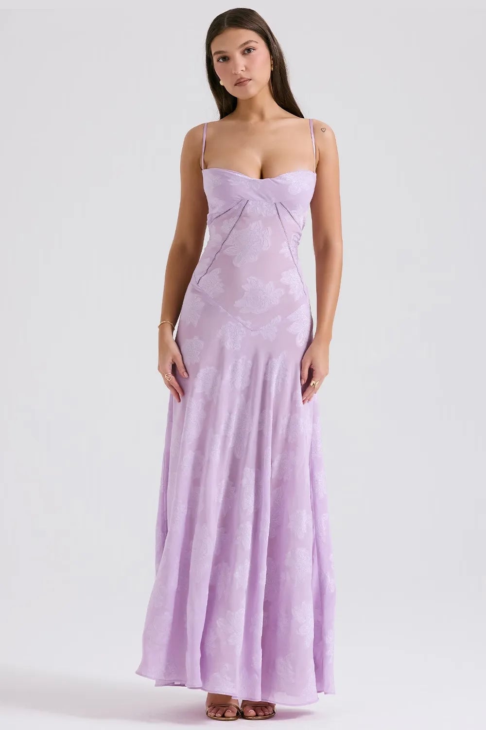 Flat lay of a long black open-back summer dress with spaghetti straps on a light background