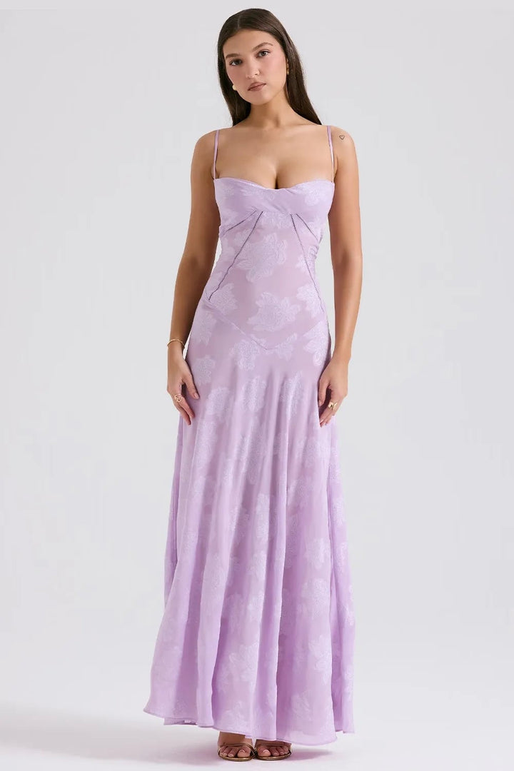 Flat lay of a long black open-back summer dress with spaghetti straps on a light background