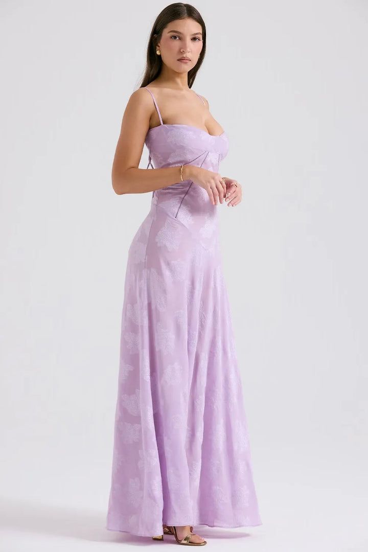 Model in a long white flowing summer dress with open back, natural outdoor lighting