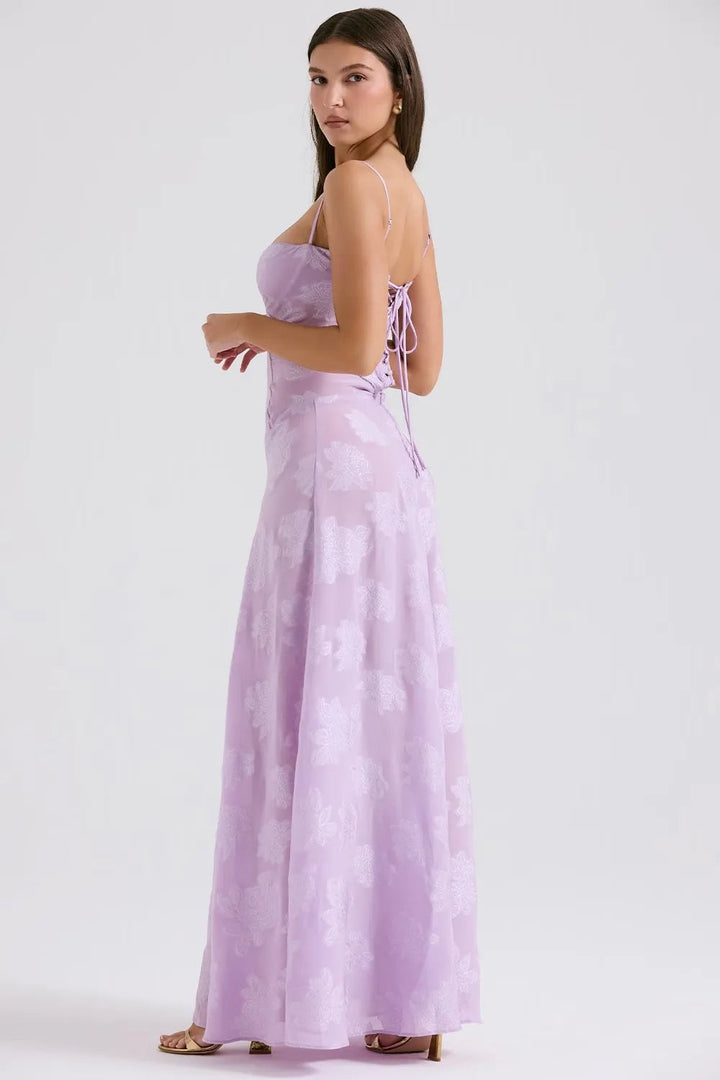 Woman in a long green open-back summer dress smiling, casual elegant style for warm weather