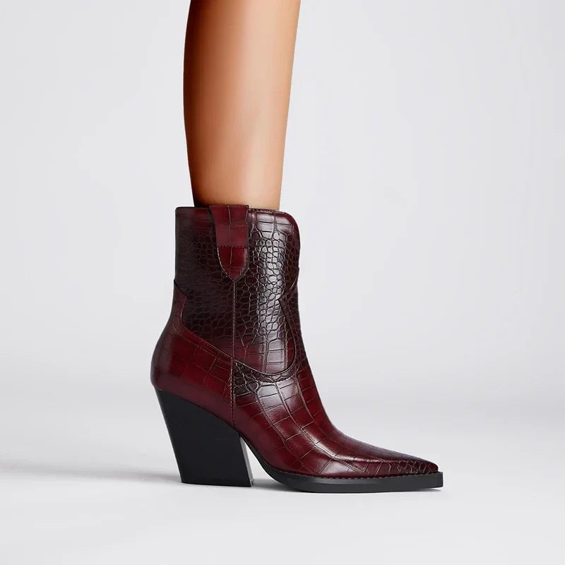 Close-up of the ankle boot's western detailing and sleek toe silhouette in wine red