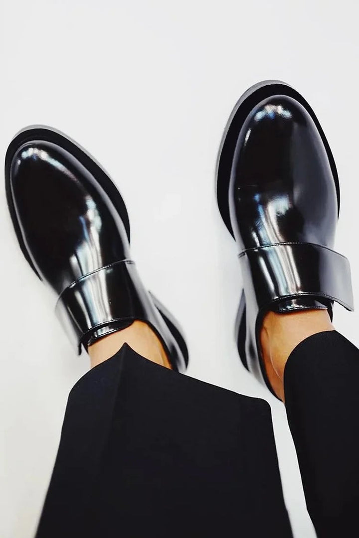 Close-up side view of black Harleigh strap loafers showing the smooth finish and flattering low-profile design