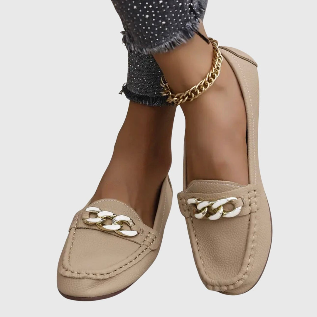 Close-up of gold chain hardware on Harlow black slip-on loafers