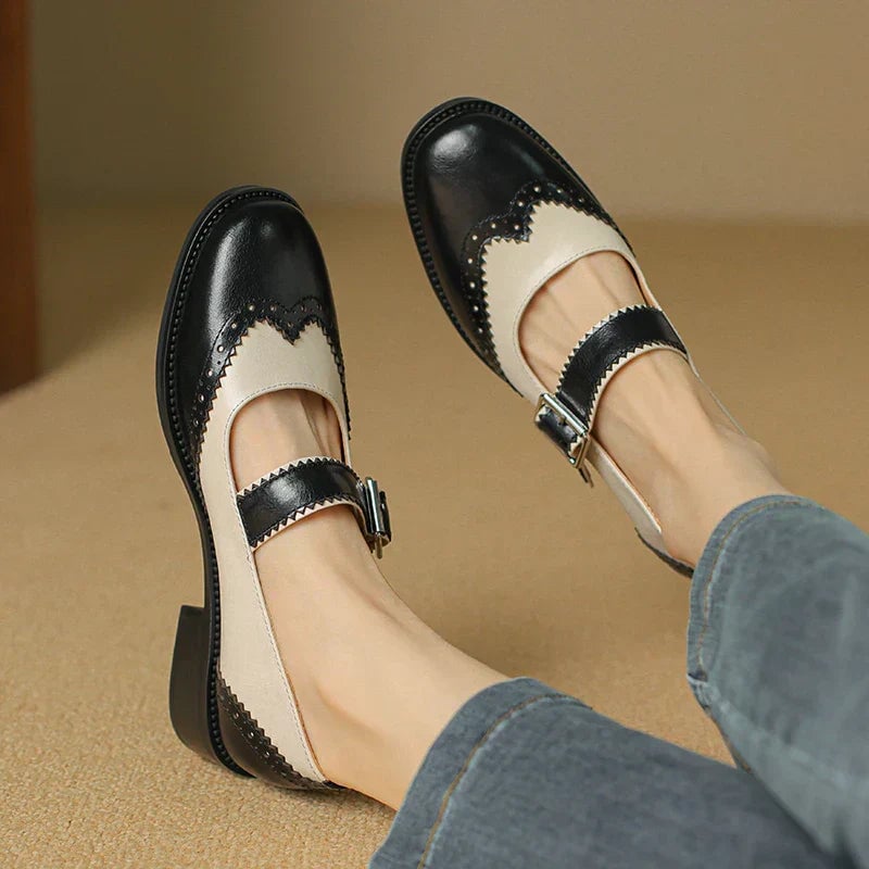 Harlow two-tone leather mary jane shoes in black and cream with brogue scalloped edging and T-strap buckle, front view