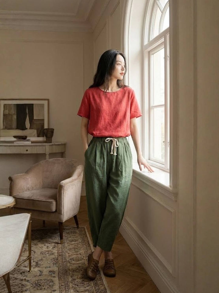 Model wearing Harper pants in apricot styled with a white tee and sandals