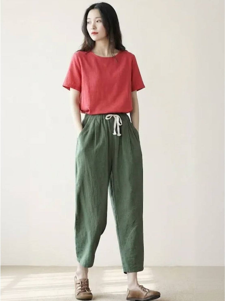 Model wearing Harper pants in navy blue styled with a linen blouse