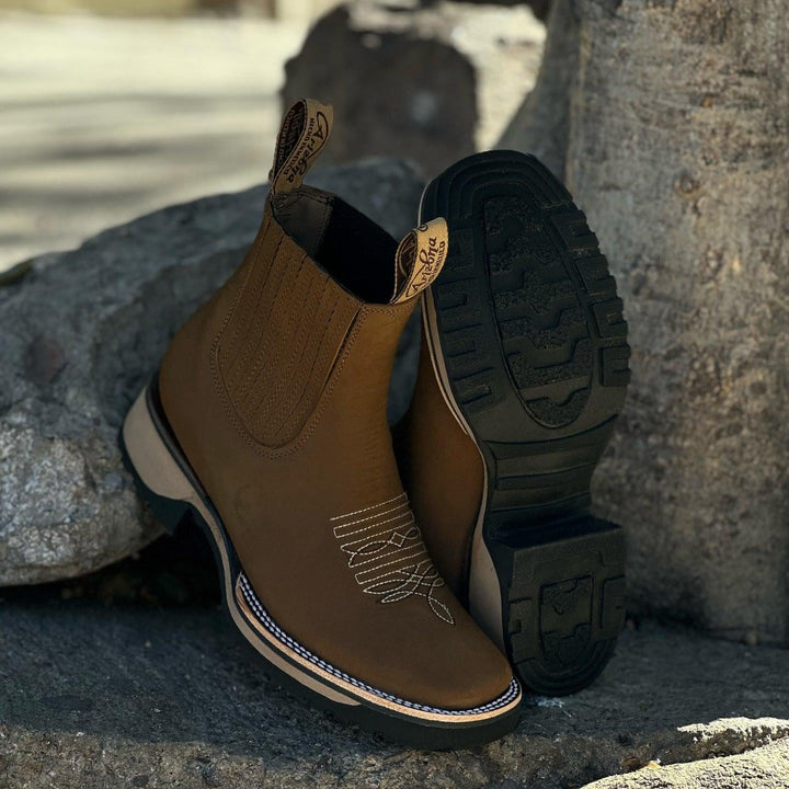 Pair of Haven cowboy boots in light brown laid flat showing the sole and overall silhouette