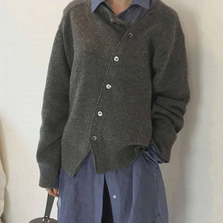 Close-up of the asymmetrical slanted button detail on the Hazel cardigan in a neutral colorway