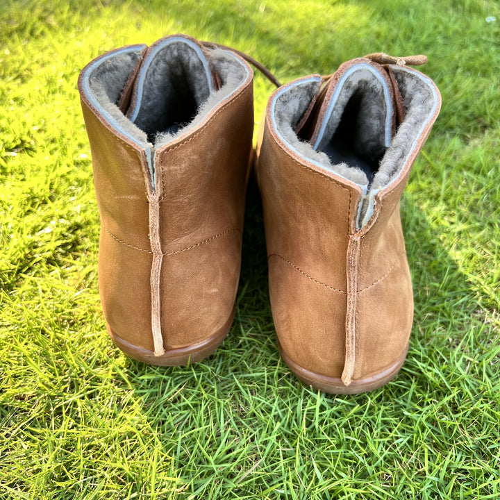 Hazel ankle boots in black worn while walking on a city sidewalk