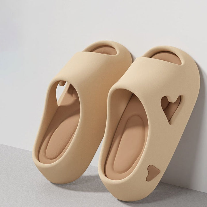 Heart flip flops in black showing slip-on silhouette