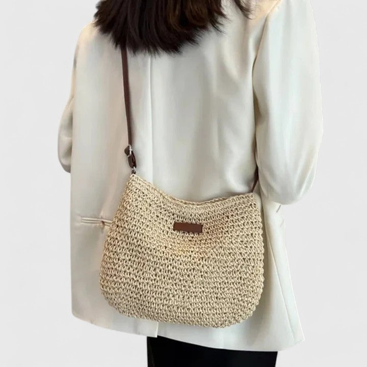 Overhead flat lay of the Hedda shoulder bag in beige alongside everyday essentials