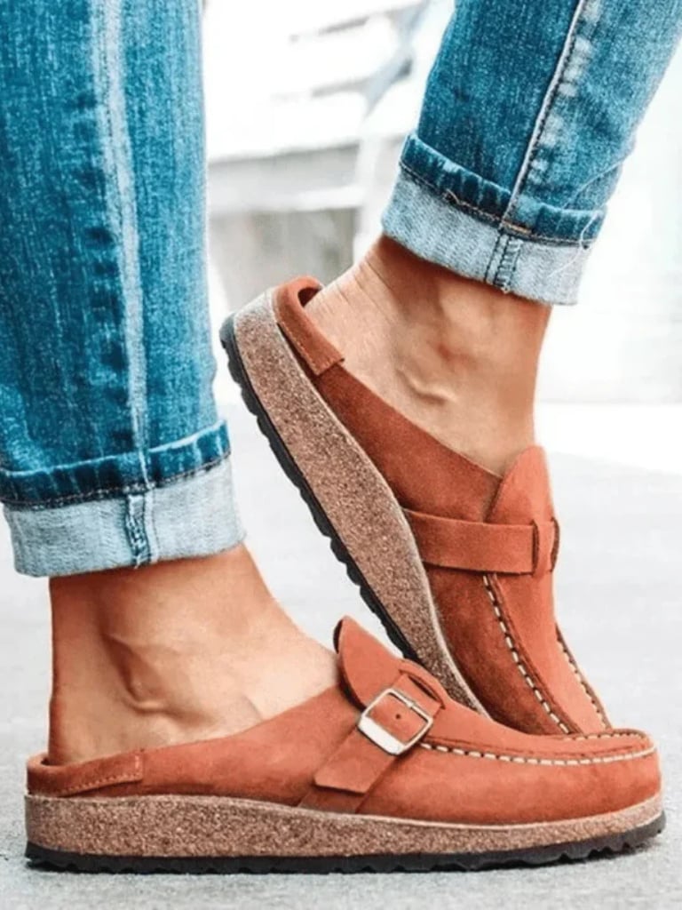 Pair of Helen comfort clogs in terracotta placed on a neutral surface