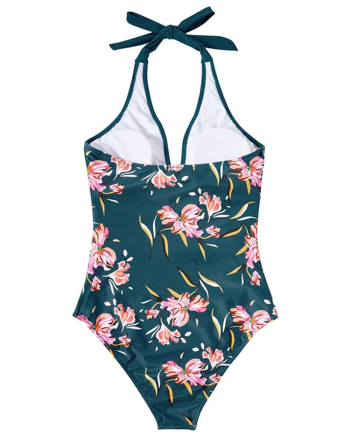 Model wearing the Hilda Black/Flowers one-piece swimsuit at the beach