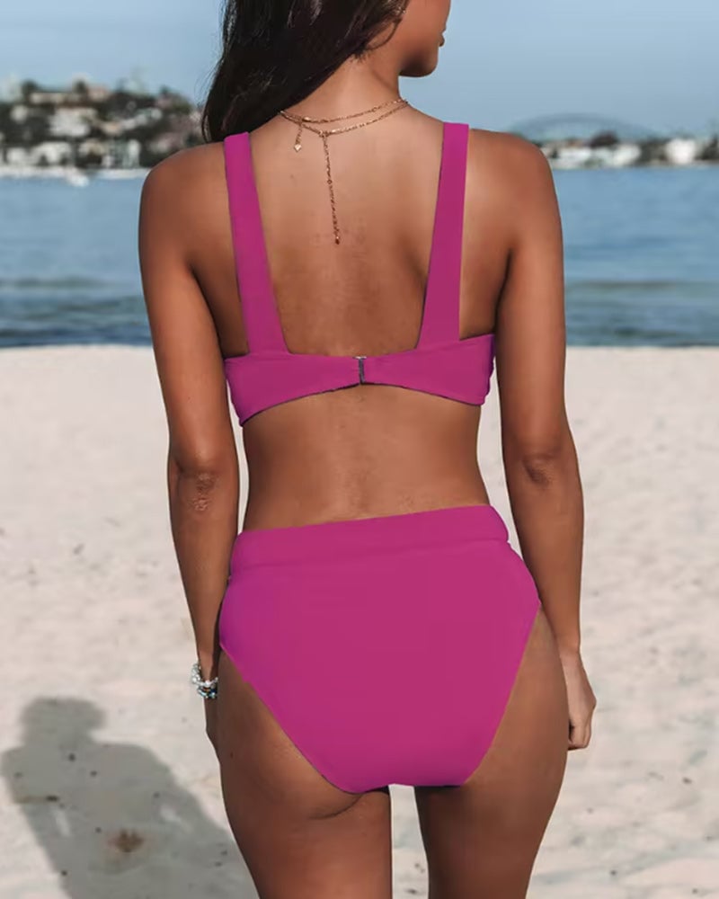 Woman wearing a solid purple high-waist one-piece swimsuit, three-quarter view