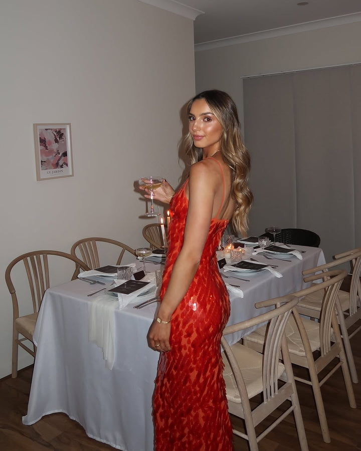 Full-length side view of the Holly red sequin dress highlighting the fluid, elongating silhouette