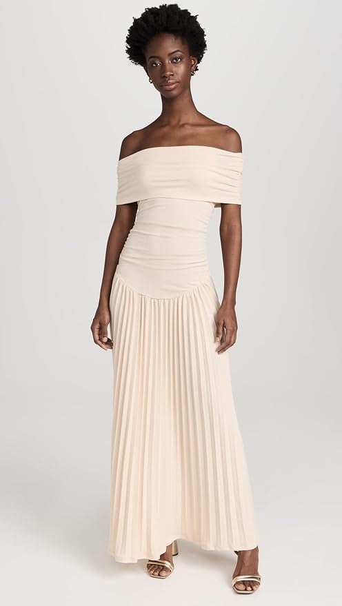 Detail shot of the flowing hem of a cream flowy maxi dress in motion against a sunny backdrop