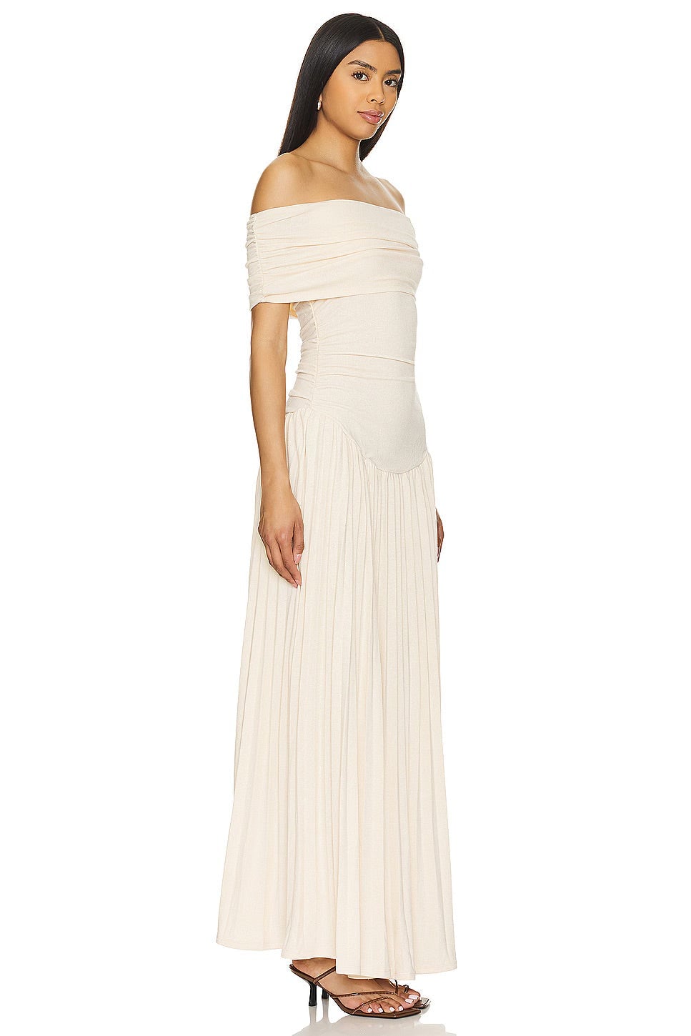 Model in a navy maxi dress paired with a woven tote bag and flat sandals for a beach-ready look