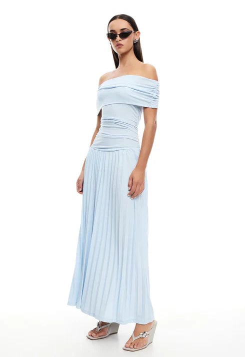 Model laughing in a navy maxi dress outdoors, showcasing ease of movement in the flowing fabric