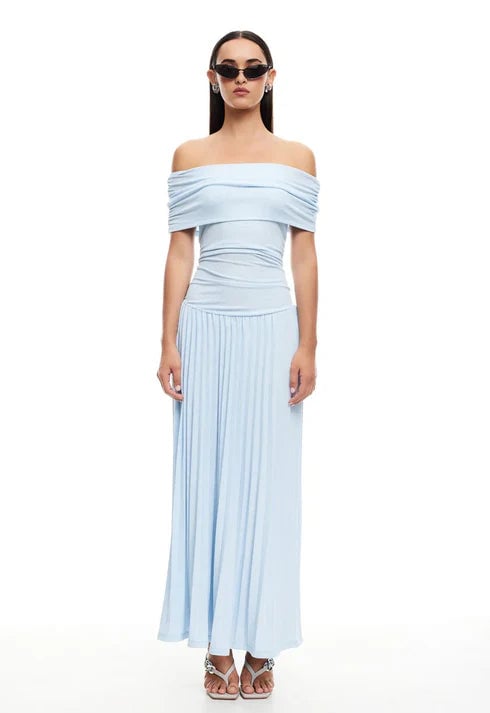 Woman in a cream maxi dress with denim jacket draped over shoulders for a casual layered summer outfit