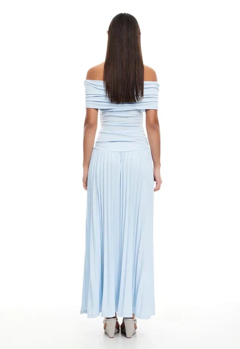 Side view of a model in sky blue maxi dress walking, showing elegant fabric movement at full length