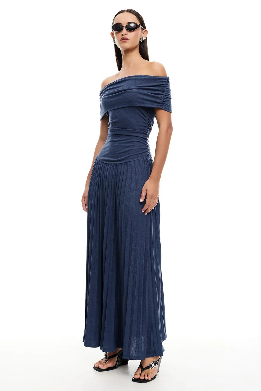 Woman in a navy flowy maxi dress at a rooftop summer event, dressed up with statement earrings