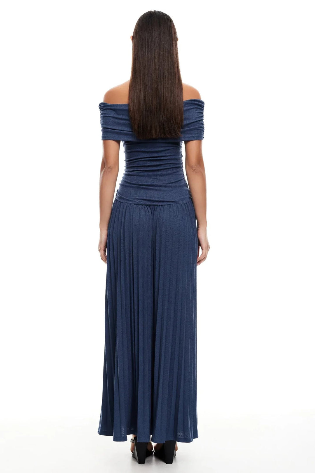 Model in a cream maxi dress seated on a patio chair, relaxed fit draping naturally and comfortably