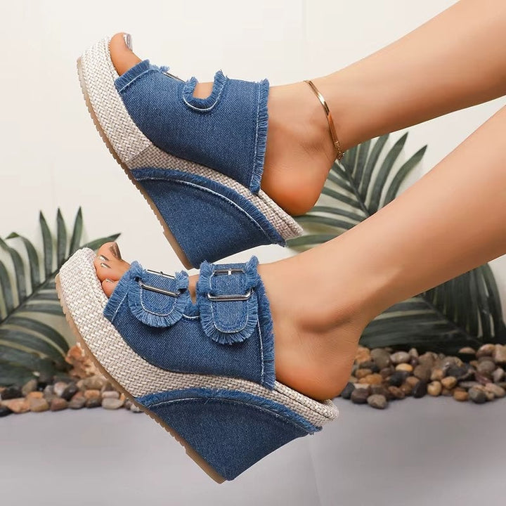 Blue denim chunky wedge sandals with adjustable buckle straps, front three-quarter view