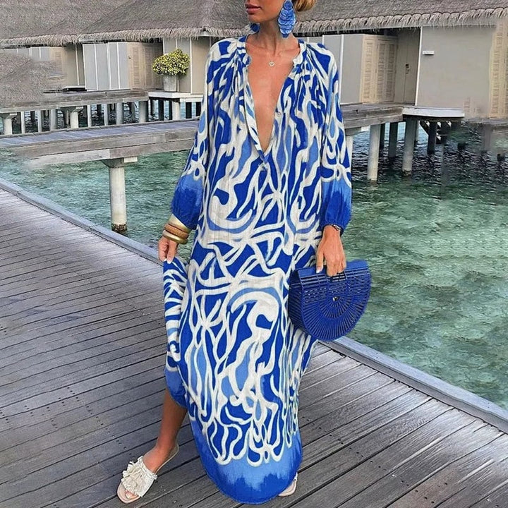 Woman in a blue flowy maxi kaftan cover-up styled for a beach resort setting