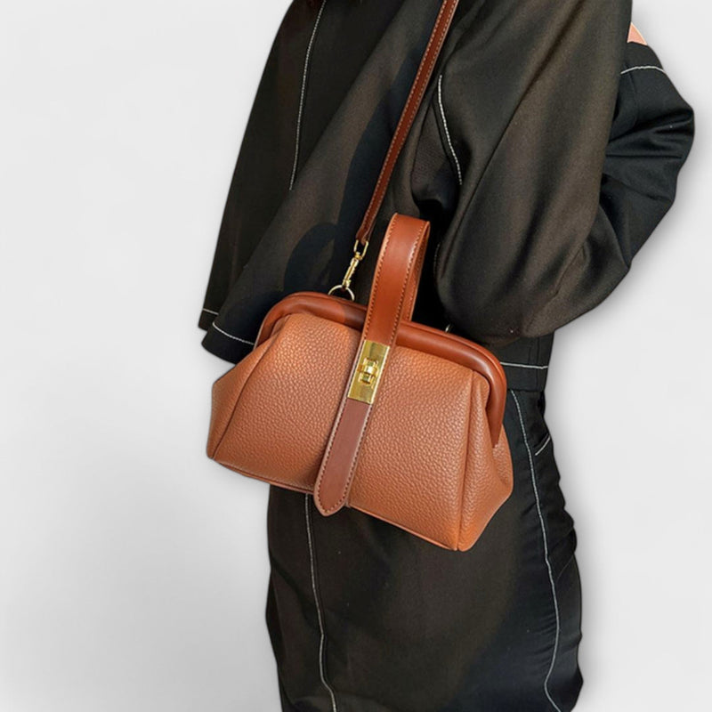 Red mini handbag with gold lock closure styled for a night out