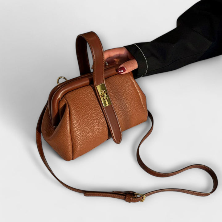 Close-up of golden lock hardware on a brown mini handbag