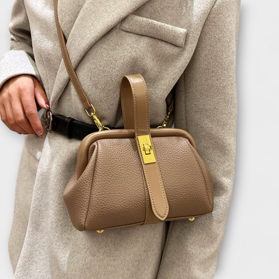 Black mini handbag held by a model dressed for an evening occasion