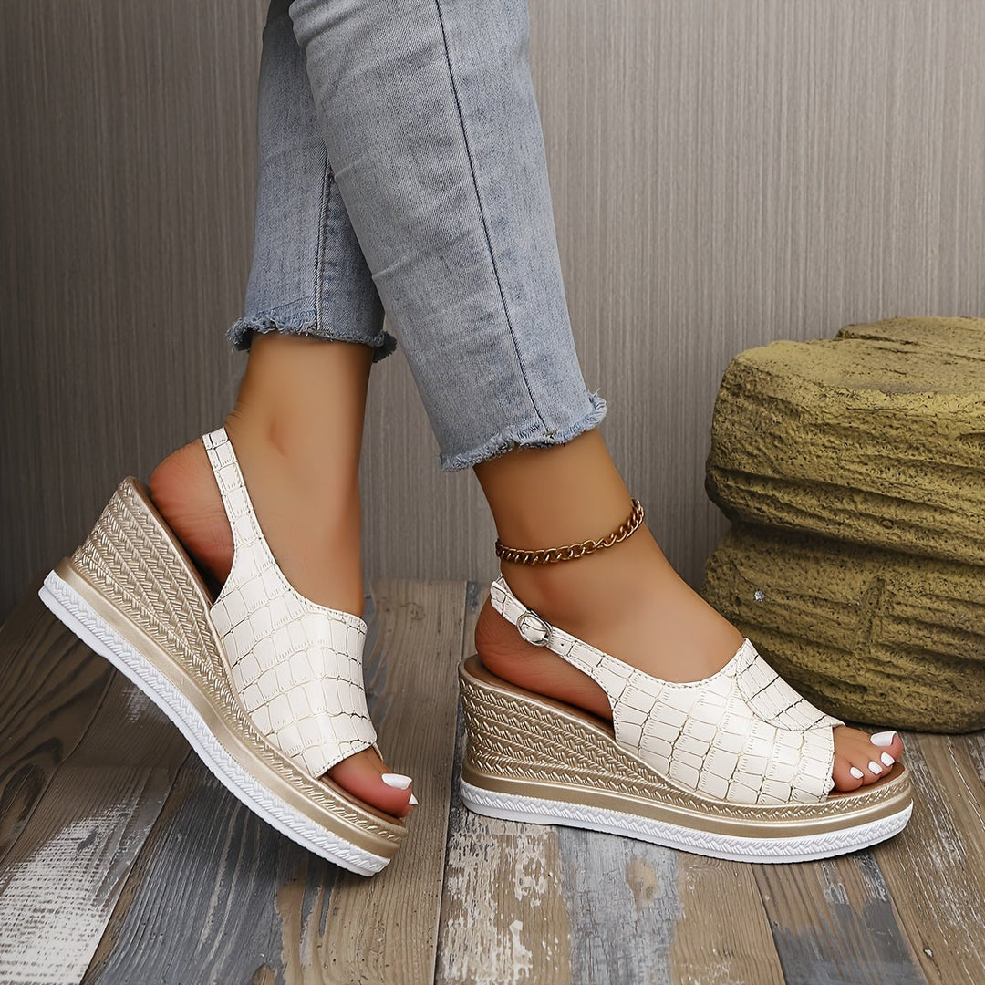 Imara white wedge sandals styled with a flowy summer dress on a woman outdoors