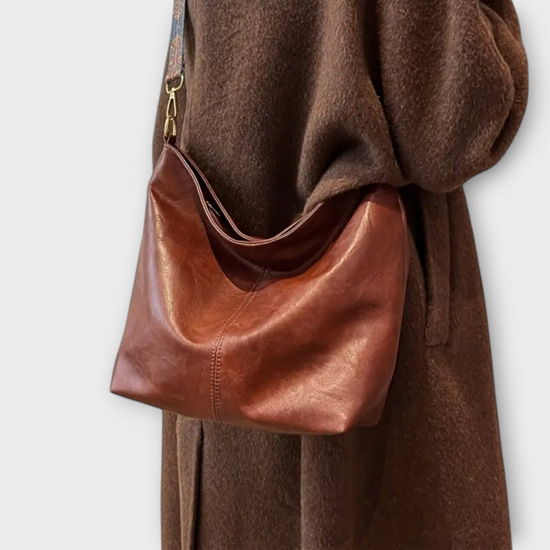 Close-up of the unique patterned shoulder strap detail on a structured shoulder bag