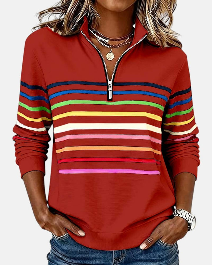 Model in navy blue rainbow striped zip sweatshirt styled with casual bottoms