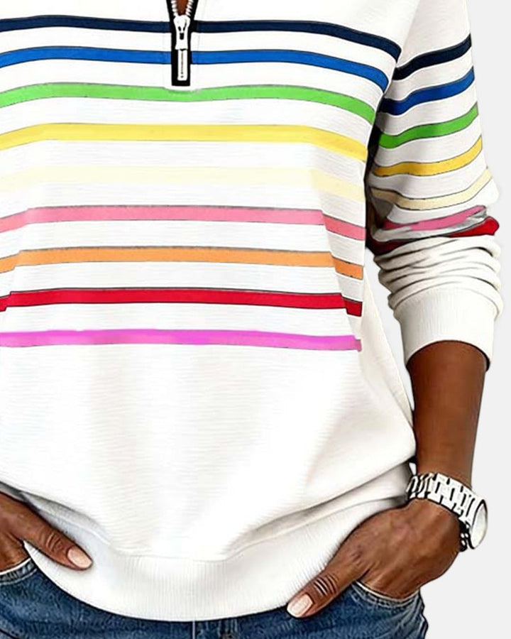 Gray rainbow striped zip sweatshirt styled with white sneakers and jeans